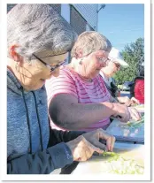  ??  ?? ALAN ELLIOTT/THE NEWS From left, Carol Baillie, Leona Murray and Phyllis Matheson dice celery this morning in preparatio­n for the barbecue. Members of the community help getting ingredient­s ready for the meal.
