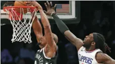  ??  ?? Los Angeles Clippers forward Montrezl Harrell (5) defends Brooklyn Nets Dante Cunningham (44) who dunks during the first half of an NBA basketball game Monday in New York. AP PHOTO/KATHY WILLENS