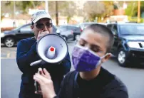  ?? (Shannon Stapleton/Reuters) ?? A PROTESTER USES a megaphone to yell to a counter-protester during a demonstrat­ion against the use of masks in Los Angeles in January.