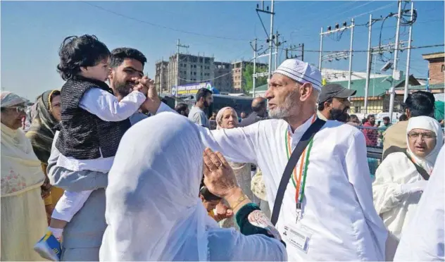  ?? Agence France-presse ?? ↑
Relatives embrace Hajj pilgrims as they leave for Makkah in Srinagar on Thursday.