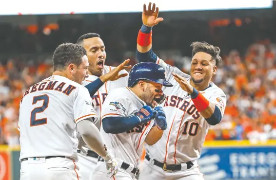  ?? Brett Coomer / Staff photograph­er ?? Jose Altuve (27) is the man of the hour after his two-run home run in the bottom of the ninth inning beat the Yankees and put the Astros back in the World Series.