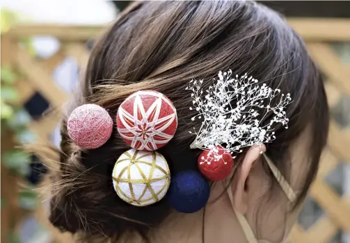  ?? ?? Top: Honjo Gotenmari from Akita Prefecture with its characteri­stic tassels; above: A kanzashi hairpin decorated with small geometric patterned temari balls.