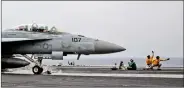  ??  ?? US Navy catapult officers, signal to an F/A-18 fighter jet pilot for safe take off, in the eastern Mediterran­ean Sea on 4 May.