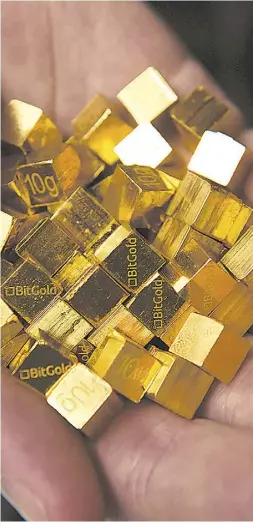  ?? PeterJ. Thompson/ National Post ?? BitGold shows off its 10-gram cubes at its Toronto office. The firm’s founders wanted to create a service that would
let people buy a Tim Hortons coffee using gold.