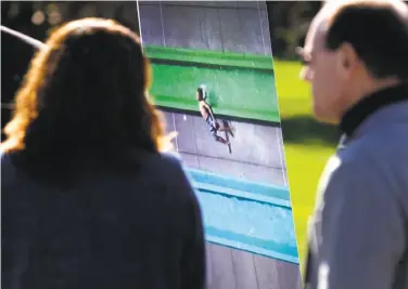  ?? Michael Macor / The Chronicle ?? Parents Susanna Jones and Ron Hayduk stand near a video frame showing their son, Jamie, being ejected from the Emerald Plunge water slide on the opening day of the Wave Waterpark in Dublin in May.