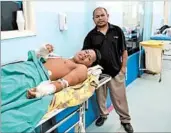  ?? MARINA LOPES/THE WASHINGTON POST ?? Rogelio Sanchez stands by his son Ronny in a hospital in Brazil where he was taken after an accident in Venezuela.