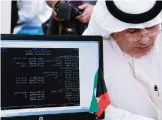  ??  ?? Former MP Abdullah Al-Tamimi’s informatio­n are seen on the monitor as he registers as a candidate in the fifth constituen­cy.