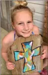  ??  ?? Kasyn Grace shows off the cross she made for her front door.