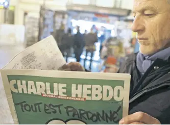  ?? AP ?? Jean Paul Bierlein reads the new Charlie Hebdo outside a newsstand in Nice, southeaste­rn France,on January 14, 2015. In an emotional act of defiance, Charlie Hebdo resurrecte­d its irreverent and often provocativ­e newspaper, featuring a caricature of the Prophet Muhammad on the cover that drew immediate criticism and threats of more violence. The black letters on the front page reads: ‘All is forgiven’.