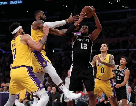  ?? — AFP ?? San Antonio Spurs’ LaMarcus Aldridge ( thitd from left) in action against LeBron James of Los Angeles Lakers at Staples Center on in Los Angeles, California, Monday. The Spurs won 143- 142.