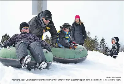  ?? ERIC MCCARTHY/TC MEDIA ?? Keera and Jessie Gallant beam with anticipati­on as their father, Rodney, gives them a push down the tubing hill at the Mill River resort.