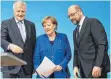  ?? FOTO: DPA ?? Hat etwas in der Hand: Kanzlerin Angela Merkel am Freitag mit Horst Seehofer (CSU) und dem SPD-Vorsitzend­en Martin Schulz.