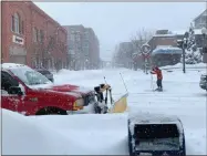  ?? NICK ZIGICH — MEDIANEWS GROUP FILE ?? A skier makes his way on Broadway and Division Street as a plow clears snow in Saratoga Springs in December.