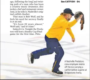  ??  ?? A Nashville Predators crew employee skates off the ice carrying a catfish before a game at Bridgeston­e Arena.