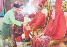  ??  ?? Wan Junaidi (left) performs ‘tepung tawar’ at a mock Malay wedding ceremony during the open house while Jamilah (second left) looks on.