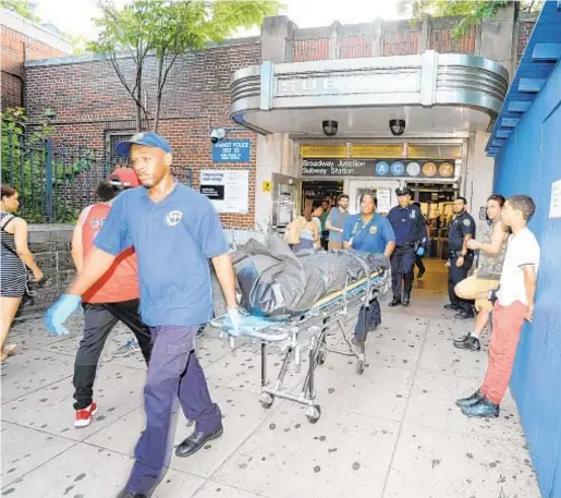  ?? SAM COSTANZA ?? Emergency crews take body from subway station at Fulton St. and Van Sinderen Ave. in Brooklyn. Witnesses said a man dragged a woman onto the tracks where they were both hit and killed.