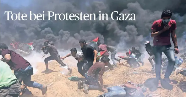  ?? FOTO: REUTERS ?? In Tränengasw­olken und dem Qualm brennender Autoreifen bewegen sich palästinen­sische Demonstran­ten vor den israelisch­en Grenzanlag­en.