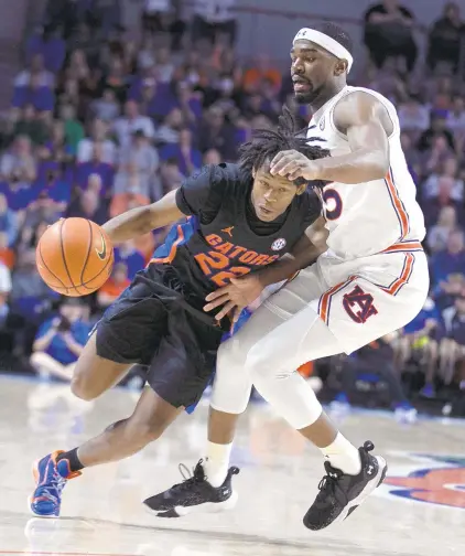  ?? ALAN YOUNGBLOOD/AP ?? Florida guard Tyree Appleby tries to drive past Auburn forward Chris Moore during Saturday’s game in Gainesvill­e, Florida.