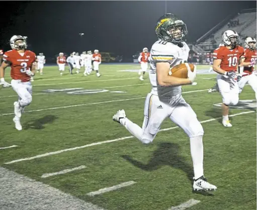  ?? Barry Reeger/ For the Post-Gazette ?? Penn-Trafford’s Caleb Lisbon heads past Peters Township defenders en route to a touchdown in a Class 5A WPIAL quaterfina­l playoff game Friday night. The Indians won on a field goal as seconds wound off the clock.