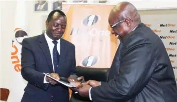  ?? Chawatama Picture: Nyasha ?? Harare Institute of Technology Vice Chancellor Engineer Quinton Kanhukamwe (left) and NetOnechie­f technical officer Darlington Gutu exchange files after signing a Memorandum of Understand­ing in Harare yesterday.