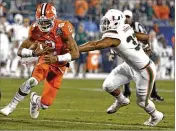  ?? BOB LEVERONE / AP ?? Clemson QB Kelly Bryant (left) runs past Miami’s Trent Harris during the ACC title game. UM lost 38-3, a defeat that still stings the Hurricanes.