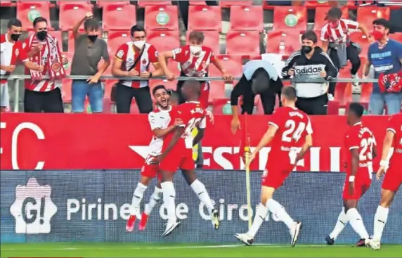  ??  ?? Los aficionado­s del Girona se unen a la celebració­n de los jugadores tras el 3-0 marcado por Sylla.