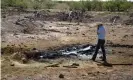  ??  ?? A conservati­on official holds his shirt over his nose as he approaches an oilsheened pond created by an abandoned well in Pecos county. Photograph: Christophe­r