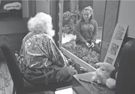  ?? JIM MONE PHOTOS/AP ?? Santa, aka Sid Fletcher, sits behind glass as he gets a Christmas wish list from Kendra Alexander of St. James, Minn., during her visit at The Santa Experience in the Mall of America in Bloomingto­n, Minn.
