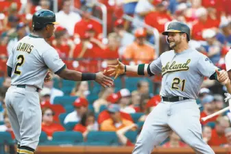  ?? Billy Hurst / Associated Press ?? Stephen Vogt (21) celebrates with Khris Davis after hitting a three-run home run off Jaime Garcia in the third inning to give the A’s a 5-1 lead over the Cardinals.