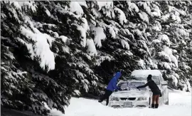  ?? STEVE HELBER —THE ASSOCIATED PRESS ?? A motorist cleans snow off cars in Richmond, Va., Monday. A winter storm kept dumping immobilizi­ng snow, sleet or freezing rain across several Southern states.