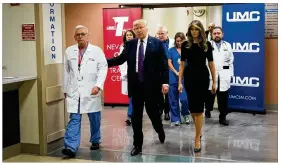  ?? DREW ANGERER / GETTY IMAGES ?? Surgeon Dr. John Fildes (from left), President Donald Trump and first lady Melania Trump walk together through University Medical Center on Wednesday in Las Vegas. The Trumps met with victims and medical profession­als.