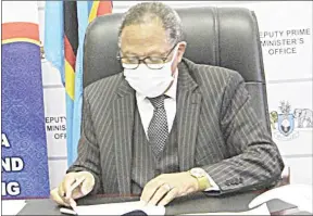  ?? (File pic) ?? Deputy Prime Minister Themba Nhlanganis­o Masuku signing the MoU between the DPM’s Office , Esicojeni Foundation and World Vision Eswatini. This was during an event held at his offices earlier this month.