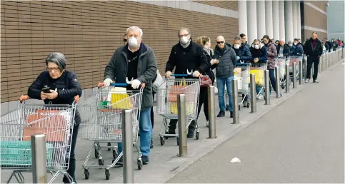  ?? Photo: EPA ?? People queue to buy groceries at a supermarke­t in Milan, Italy, in 2020. Two years of economic disruption from the pandemic is one of the stagflatio­nary forces in play.