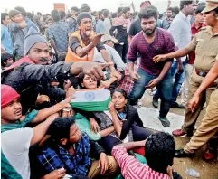  ??  ?? Protesters supporting jallikattu try to hold on to each other as police try to remove them from the Marina beach in Chennai on Monday. Protesters attacked a police station with stones and set some vehicles on fire on Monday in anger at being forcibly...