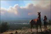  ?? FELICIA FONSECA — THE ASSOCIATED PRESS ?? Janetta Kathleen and her horse, Squish, watch Sunday as smoke rises above neighborho­ods on the outskirts of
Flagstaff, Ariz.