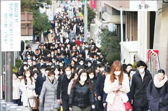  ??  ?? People wear masks as they commute during the morning rush hour, Feb 20, in Chuo district in Tokyo. A test event for the Tokyo Olympics scheduled for later this month that would have involved
some non-Japanese athletes is being rejiggered because of fear of the spreading virus from China. It will now involve only Japanese athletes. (AP)