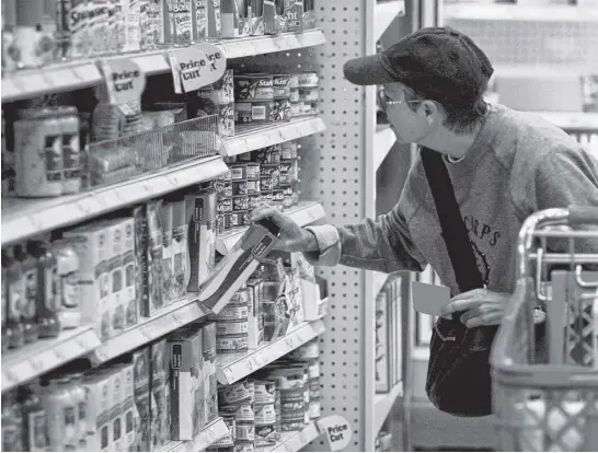  ?? REUTERS FILE ?? A customer shops for grocery items at a Target store in Los Angeles.