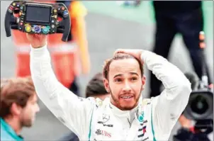  ?? AFP ?? Lewis Hamilton celebrates his fifth F1 drivers’ title after the Mexico Grand Prix at the Hermanos Rodriguez circuit in Mexico City on Sunday.