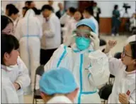  ?? ZHU XINGXIN / CHINA DAILY ?? A student tries on a hazmat suit at Beijing No 15 Middle School on Friday. The Chinese Center for Disease Control and Prevention held activities for students to learn about infectious diseases and biolabs, ahead of National Security Education Day,...