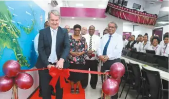  ??  ?? Grand opening … Air Niugini’s managing director Alan Milne (cutting ribbon) and Air Niugini staff at the opening of the airline’s new flagship sales office in Waigani.