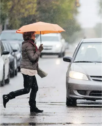  ?? KAYLE NEIS ?? This pedestrian was dressed for the damp, chilly weather in Saskatoon on Friday. .