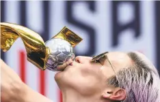  ?? Johannes Eisele / AFP / Getty Images ?? Megan Rapinoe kisses the World Cup trophy in New York.