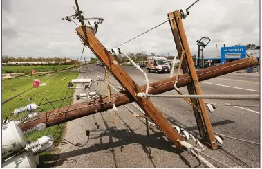  ?? (AP/Steve Helber) ?? Ambulances pass a downed power pole in LaPlace, La., on Monday after Hurricane Ida moved through.