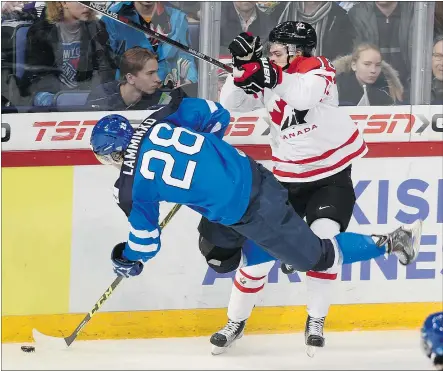  ?? — THE CANADIAN PRESS ?? Canada’s Jake Virtanen tries to knock Finland’s Juho Lammikko off the puck during first-period action on Saturday. Canada dropped a disappoint­ing 6-5 game to Finland.