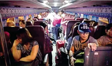  ?? CELIS/AFP NOEL ?? Workers return home from Kuwait on a bus after arriving at Manila Internatio­nal Airport on Saturday.