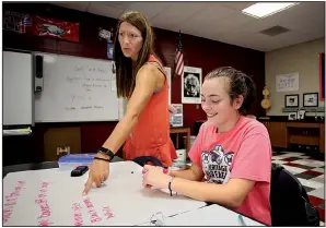  ?? NWA Democrat-Gazette/DAVID GOTTSCHALK ?? Faith Cornog, a senior at Heritage High School, listens Thursday as physics teacher Tiffany Taylor reviews a white board during a class at the high school in Rogers.