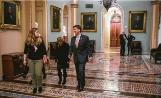  ?? Al Drago / New York Times ?? Sen. Ben Sasse, R-Neb., escorts his children before heading to the Senate floor for a vote, one of many to be taken Wednesday night and Thursday morning amid the Senate’s “vote-a-rama.”