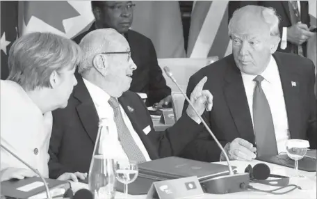  ?? Jonathan Ernst Pool Photo ?? PRESIDENT Trump and German Chancellor Angela Merkel listen to Tunisian President Beji Caid Essebsi at the Group of 7’s expanded session in Taormina, Italy. Trump tweeted he would decide in the coming week whether to pull the U.S. out of the Paris...