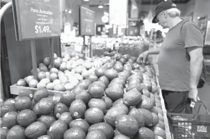  ?? Associated Press ?? n A man shops for avocados Monday at a Whole Foods Market in New York. Amazon is moving swiftly to make big changes at Whole Foods, saying it plans to cut prices on avocados, bananas, eggs, salmon, beef and more. Amazon has completed its $13.7 billion...
