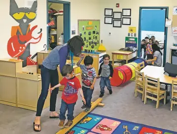  ?? ROBERT NOTT/NEW MEXICAN FILE PHOTOS ?? Nye Early Childhood Center teacher Brittany Behenna Griffith earlier this year helps preschool students through an obstacle course designed to test their motor and social skills and ability to count.